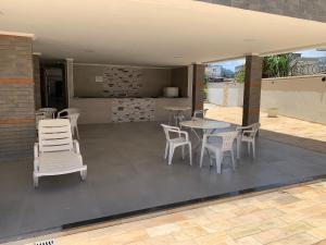 a patio with white chairs and tables on a roof at Apartamento no Itagua - Ubatuba in Ubatuba
