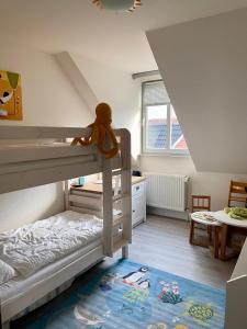 een slaapkamer met 2 stapelbedden en een teddybeer bovenop bij Haus Sommerwind; Wohnung 3 in Sankt Peter-Ording