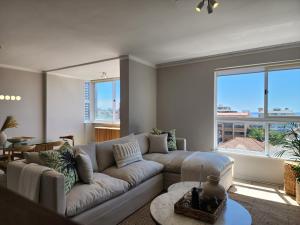 salon z kanapą i dużym oknem w obiekcie Sandy Lodge 201 w Kapsztadzie