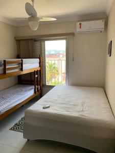 a bedroom with two bunk beds and a window at Apartamento no Itagua - Ubatuba in Ubatuba