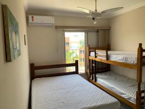 two bunk beds in a room with a window at Apartamento no Itagua - Ubatuba in Ubatuba