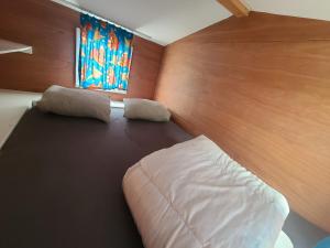 - une chambre avec un grand lit et une fenêtre dans l'établissement Bungalow Belle Vue en Tiny-house - Camping International - Bomal - Durbuy, à Durbuy