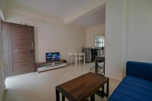 ein Wohnzimmer mit einem blauen Sofa und einem Tisch in der Unterkunft HomeSlice Sarjapur - 1BHK Serviced Apartment in Bangalore