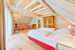 a bedroom with two beds and a living room at Schwanen Boutique Hotel & Restaurant Metzingen in Metzingen