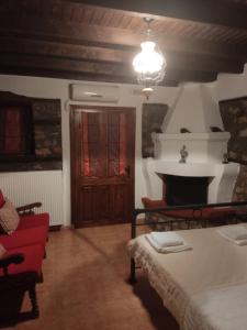 a living room with a bed and a fireplace at Traditional Guesthouse Archontoula in Palaios Panteleimon