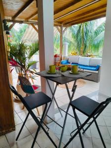 una mesa y sillas en una sala de estar con sofá en Coconing logements studios et maisons, en Sainte-Anne