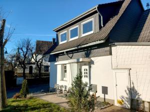 une maison blanche avec un toit noir dans l'établissement FeWo-Haus-Junkernhof, à Medebach