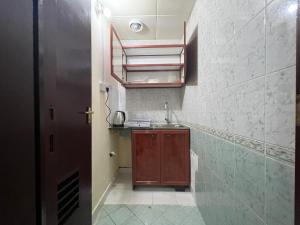 a small bathroom with a sink and a mirror at Furnished Studio Apartment in Abu Dhabi