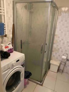 een wasmachine in een badkamer met een douche bij Balat’ta huzurlu bir konaklama in Istanbul