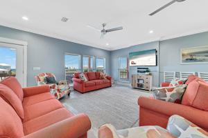 a living room with orange furniture and a flat screen tv at Ocean Overlook in Gulf Shores