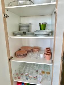 a pantry with dishes and plates on shelves at Casa Encanto das Dunas in Santo Amaro