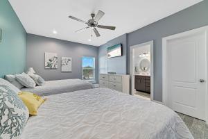 a bedroom with two beds and a ceiling fan at Ocean Overlook in Gulf Shores +45 photos