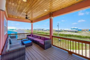 a porch with purple furniture and a view of a field at Ocean Overlook in Gulf Shores
