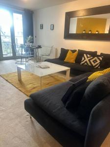 ein Wohnzimmer mit einem Sofa und einem Tisch in der Unterkunft The Drake Apartment in Plymouth