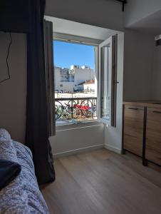 a bedroom with a large window with a balcony at Holiday Nice Studio in Nice
