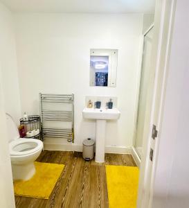 Private Modern Ensuite Room near Etihad Stadium في مانشستر: حمام مع حوض أبيض ومرحاض