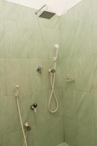 y baño verde con ducha y manguera. en Chimaca Bay Hotel, en Arugam Bay