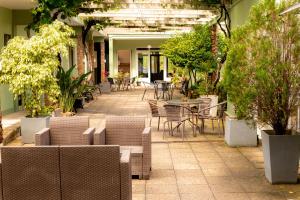 um pátio exterior com mesas, cadeiras e plantas em Hotel Internacional em Chuy