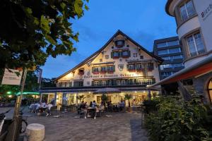 a large building with people sitting outside of it at Lake Lucerne Paradise apartment in Brunnen