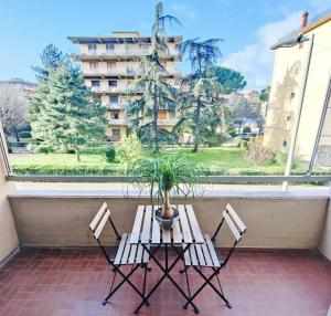 uma mesa e cadeiras numa varanda com um vaso de plantas em Florence Harmony em Florença