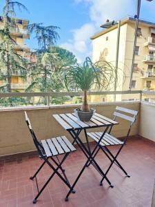 uma mesa e duas cadeiras numa varanda com um vaso de plantas em Florence Harmony em Florença