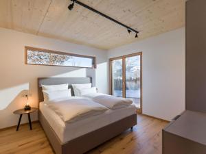 a bedroom with a large bed with a window at Penning.Tirol in Hopfgarten im Brixental