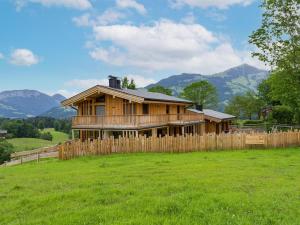una casa de madera en un campo con una valla en Penning.Tirol, en Hopfgarten im Brixental