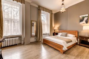 a bedroom with a bed and two windows at Auberge La Chouette in Quebec City