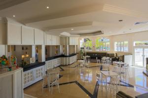 uma grande cozinha com cadeiras e mesas num quarto em Djerba Sun Beach, Hotel & Spa em Houmt Souk
