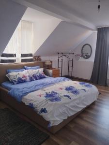 ein Schlafzimmer mit einem Bett mit blauen Blumen darauf in der Unterkunft Cabana Speranta in Porumbacu de Sus