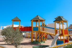 un colorido parque infantil con un tobogán en la arena en Djerba Sun Beach, Hotel & Spa en Houmt El Souk