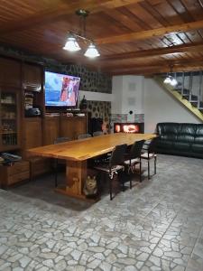 einen großen Holztisch im Wohnzimmer mit Sofa in der Unterkunft Cabana Speranta in Porumbacu de Sus