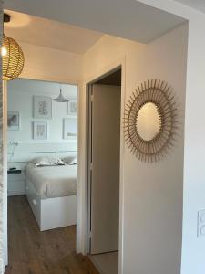 - une chambre avec un lit et un miroir mural dans l'établissement Cosy's Terrasse, à Larmor-Plage
