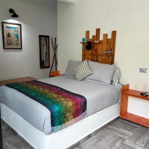 a bed with a colorful blanket on top of it at teki-sha home&suites in Bacalar