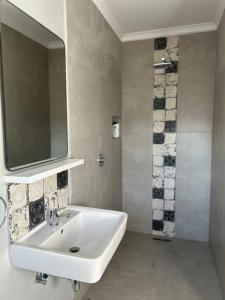 a bathroom with a white sink and a mirror at Self contained flat in Sandton