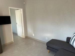 a living room with a couch and an open door at Self contained flat in Sandton
