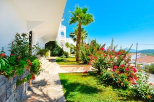 a house with a garden with flowers and a palm tree at Villa Lycia in Ortaca