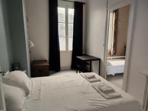 ein Schlafzimmer mit einem weißen Bett und einem Fenster in der Unterkunft Charming apartment Bordeaux center in Bordeaux