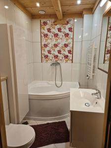 a bathroom with a tub and a toilet and a sink at Domek Góralski Amelka in Poronin