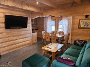 a living room with a couch and a table and a television at Domek Góralski Amelka in Poronin