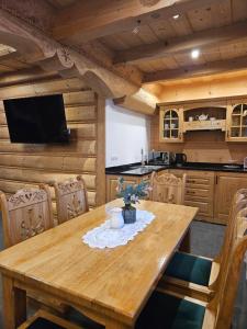 a dining room with a wooden table with chairs at Domek Góralski Amelka in Poronin +4 photos