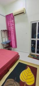Cette chambre comprend un lit, une fenêtre et un tapis. dans l'établissement Homestay Kaklong, à Kuala Terengganu