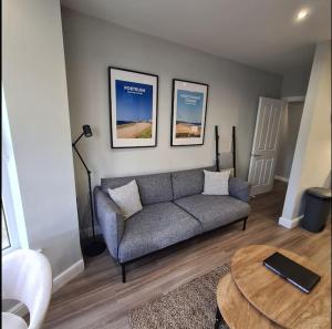 ein Wohnzimmer mit einem Sofa und einem Tisch in der Unterkunft The Cove Apartment, Portstewart near Prom, Parking in Portstewart