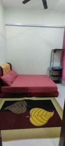 a bedroom with a bed and a rug with bananas on it at Homestay Kaklong in Kuala Terengganu