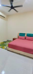 Ce lit se trouve dans un dortoir blanc doté d'un ventilateur de plafond. dans l'établissement Homestay Kaklong, à Kuala Terengganu