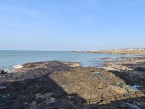 a rocky shore with the ocean in the background at The Cove Apartment, Portstewart near Prom, Parking in Portstewart