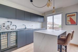 a kitchen with blue cabinets and a white counter top at Nice apartment with balcony St Genès and parking in Bordeaux