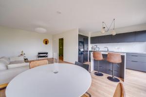 a kitchen and living room with a white table and chairs at Nice apartment with balcony St Genès and parking in Bordeaux