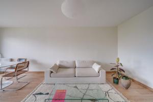 a living room with a white couch and a table at Nice apartment with balcony St Genès and parking in Bordeaux