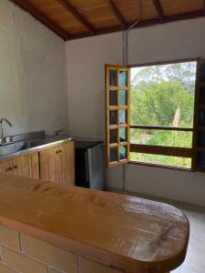een keuken met een houten tafel en een raam bij Xplora Hostel in Caldas